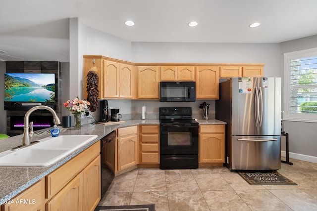 kitchen with sink, light brown cabinets, and black appliances