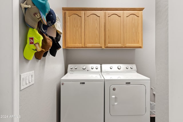 clothes washing area featuring cabinets and independent washer and dryer