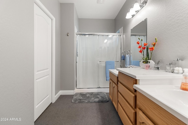 bathroom with vanity and a shower with door