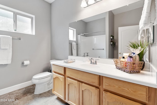 bathroom featuring toilet, walk in shower, and vanity