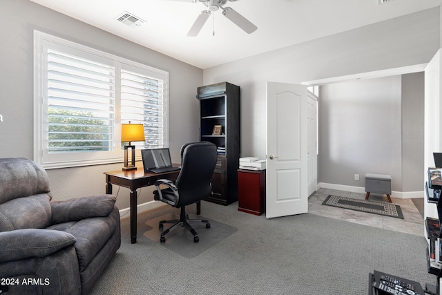 home office featuring light carpet and ceiling fan