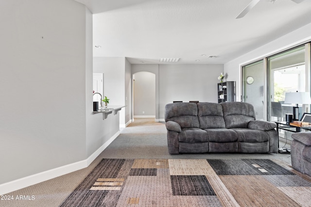 carpeted living room with ceiling fan