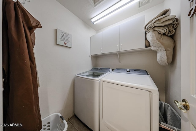 washroom with tile patterned floors, visible vents, cabinet space, and independent washer and dryer