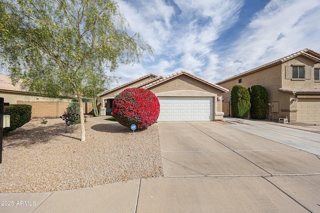 view of front of home with fence, stucco siding, concrete driveway, a garage, and a tiled roof