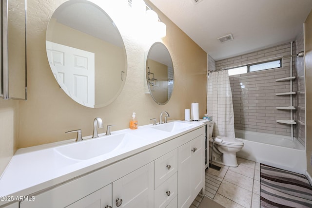 bathroom with a sink, toilet, double vanity, and tile patterned flooring