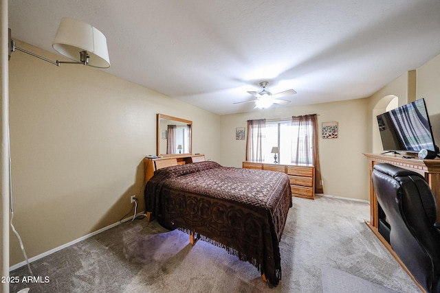 bedroom featuring light colored carpet, baseboards, and a ceiling fan