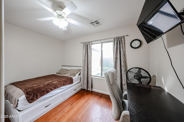 bedroom with visible vents, baseboards, a ceiling fan, and light wood finished floors