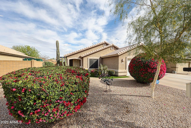 view of side of home featuring stucco siding, fence, and a tile roof