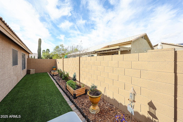 view of yard with a garden and a fenced backyard