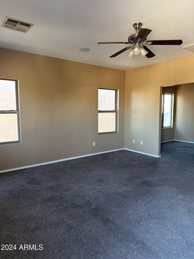 carpeted spare room with a healthy amount of sunlight and ceiling fan