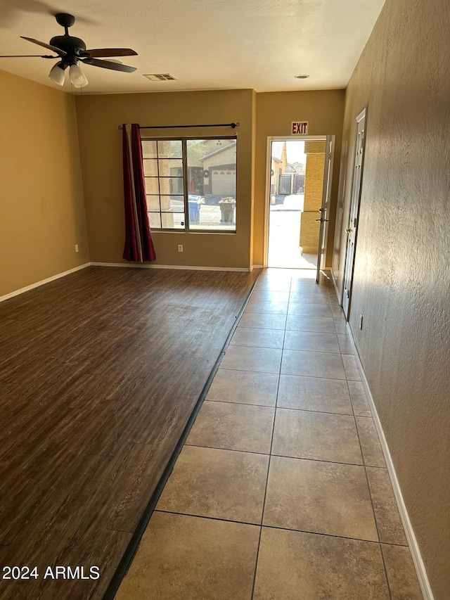 tiled empty room with ceiling fan