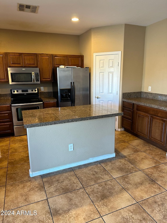 kitchen featuring a kitchen island, stainless steel appliances, and tile patterned flooring