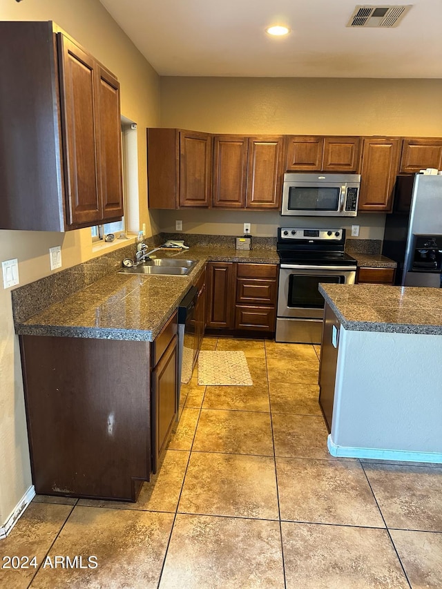 kitchen with sink, light tile patterned flooring, and stainless steel appliances