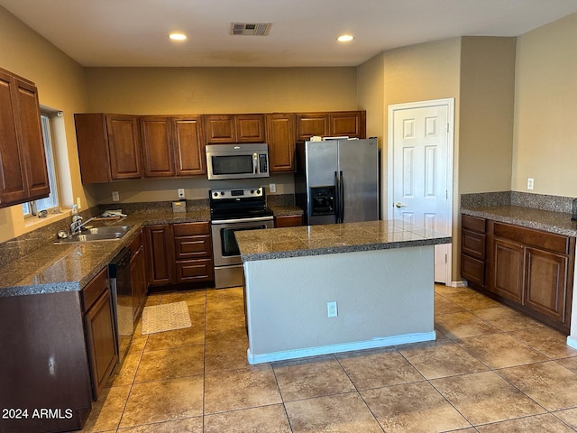 kitchen with a center island, stainless steel appliances, sink, and light tile patterned floors