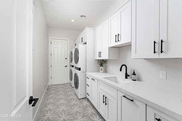 3356 E Vallejo Ct, Gilbert, AZ 85298 - washroom with stacked washer / dryer, cabinet space, a sink, baseboards, and visible vents