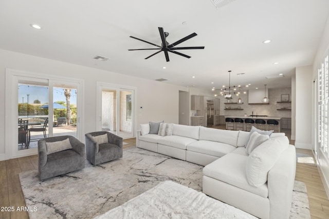 3356 E Vallejo Ct, Gilbert, AZ 85298 - living area with light wood finished floors, recessed lighting, visible vents, and ceiling fan with notable chandelier