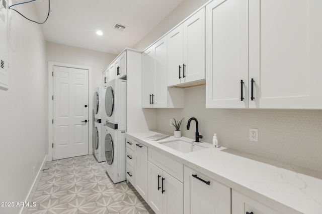 3356 E Vallejo Ct, Gilbert, AZ 85298 - clothes washing area with a sink, cabinet space, visible vents, baseboards, and stacked washer / dryer