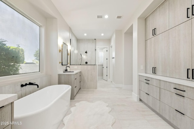 3356 E Vallejo Ct, Gilbert, AZ 85298 - bathroom with a sink, a walk in shower, two vanities, a freestanding bath, and visible vents