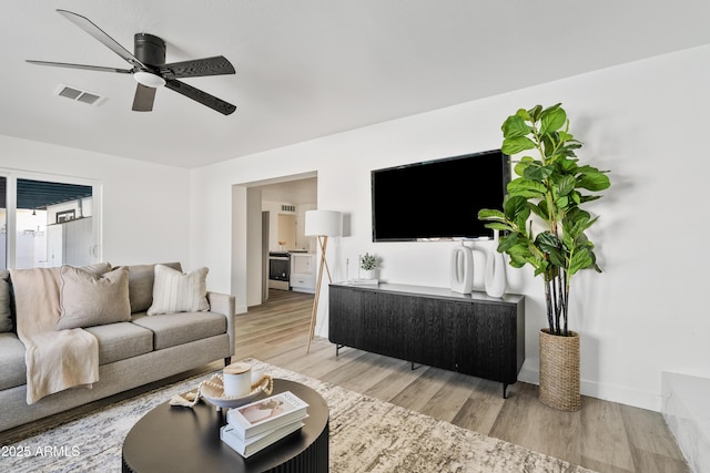 living room featuring ceiling fan and wood-type flooring