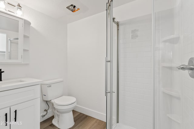 bathroom featuring toilet, vanity, walk in shower, and hardwood / wood-style floors