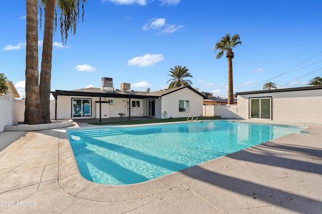 view of pool with cooling unit and a patio area