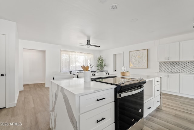 kitchen with white cabinetry, electric stove, ceiling fan, light hardwood / wood-style flooring, and tasteful backsplash