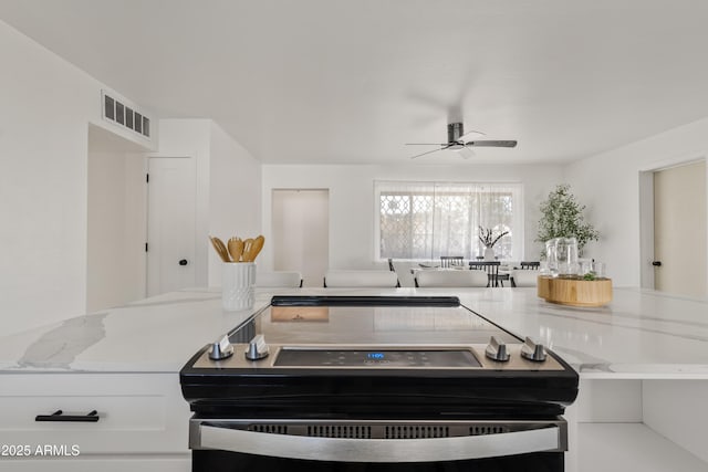 kitchen with ceiling fan, white cabinetry, electric stove, and light stone countertops