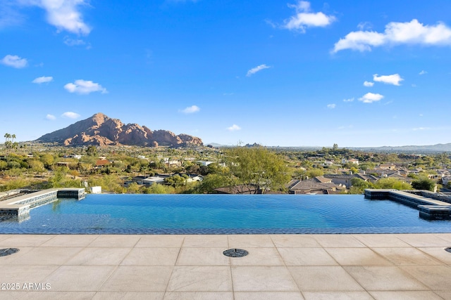 view of swimming pool with a mountain view