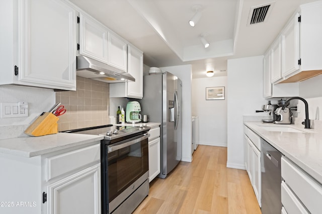 kitchen with sink, stainless steel appliances, light wood-type flooring, and white cabinets