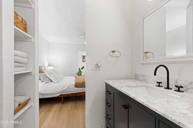 bathroom featuring hardwood / wood-style flooring, ceiling fan, and vanity