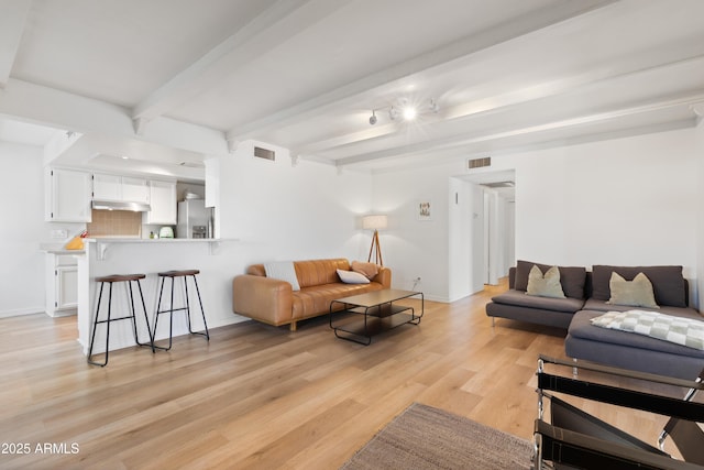 living room featuring light wood-type flooring and beamed ceiling