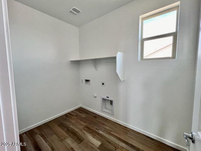 clothes washing area featuring visible vents, dark wood-type flooring, gas dryer hookup, laundry area, and electric dryer hookup