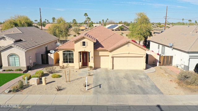 view of front of property with concrete driveway, a tiled roof, an attached garage, fence, and stucco siding