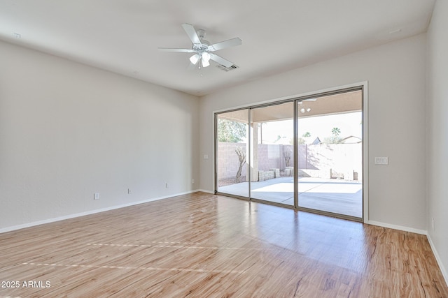 empty room with visible vents, ceiling fan, light wood-style flooring, and baseboards