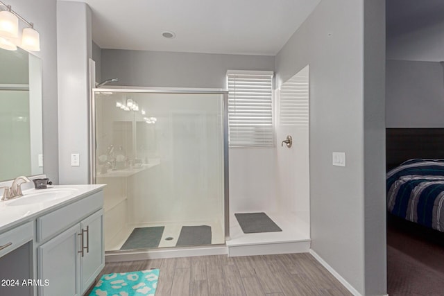 bathroom featuring hardwood / wood-style floors, vanity, and walk in shower