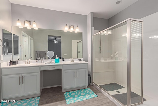 bathroom featuring wood-type flooring, vanity, an enclosed shower, and ceiling fan