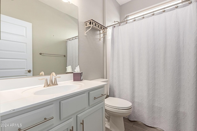 bathroom with toilet, vanity, and hardwood / wood-style flooring