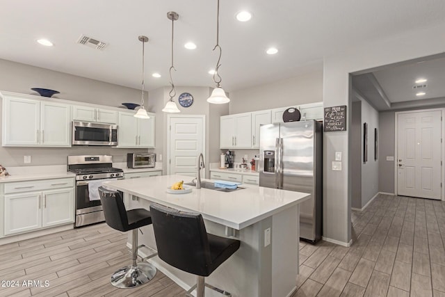 kitchen featuring pendant lighting, white cabinetry, and stainless steel appliances