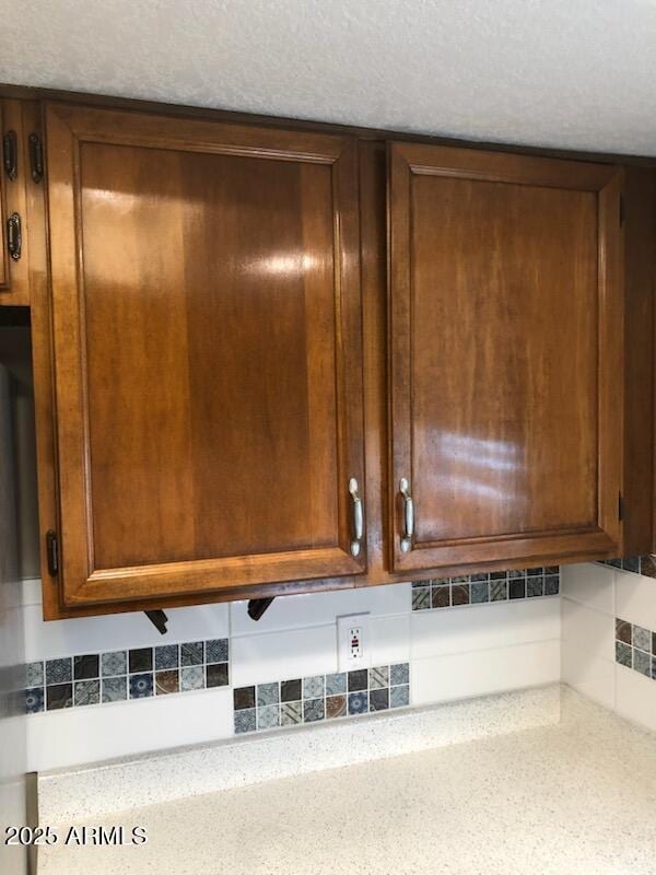 room details featuring a textured ceiling and decorative backsplash