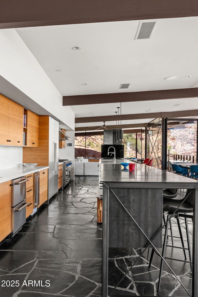 4925 E Red Rock Dr Unit 43, Phoenix, AZ 85018 - kitchen with modern cabinets, high end stainless steel range oven, beverage cooler, brown cabinets, and light countertops