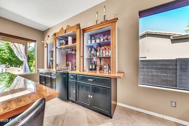 747 E Meadow Ln, Phoenix, AZ 85022 - bar featuring light tile patterned floors, baseboards, stove, and wet bar