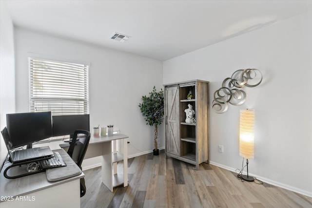 office featuring wood finished floors, visible vents, and baseboards