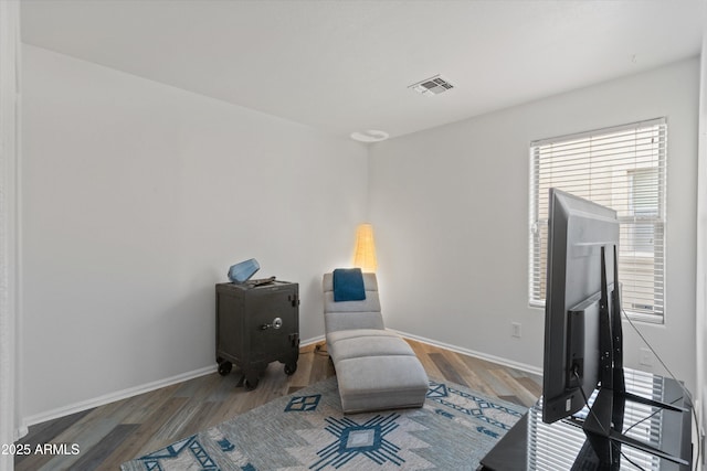 living area featuring wood finished floors, visible vents, and baseboards