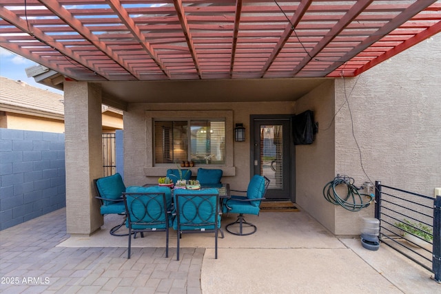 view of patio with outdoor dining area, fence, and a pergola