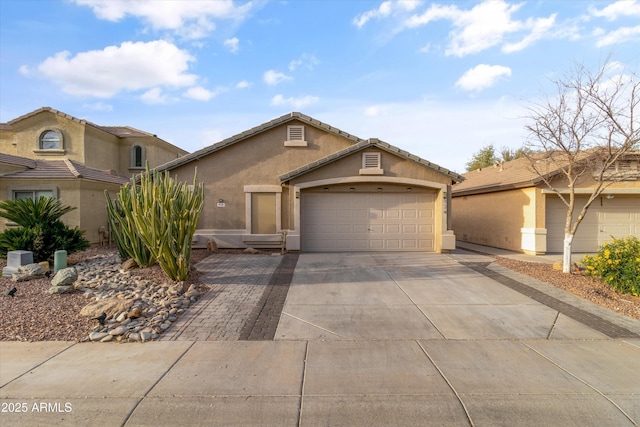 view of front of house with concrete driveway, an attached garage, a tile roof, and stucco siding