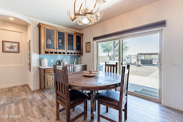 dining space featuring light wood-type flooring, visible vents, and baseboards