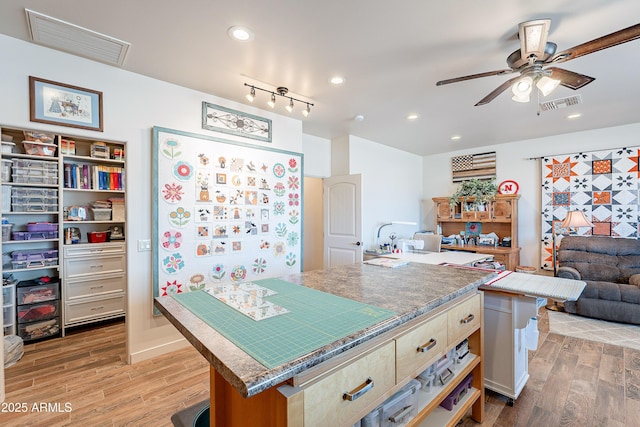 kitchen featuring light wood-style floors, a kitchen island, visible vents, and open floor plan