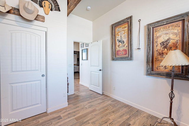 corridor featuring baseboards and light wood-style floors