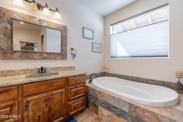 bathroom featuring a garden tub and vanity