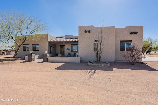 view of front of home with a tile roof and stucco siding